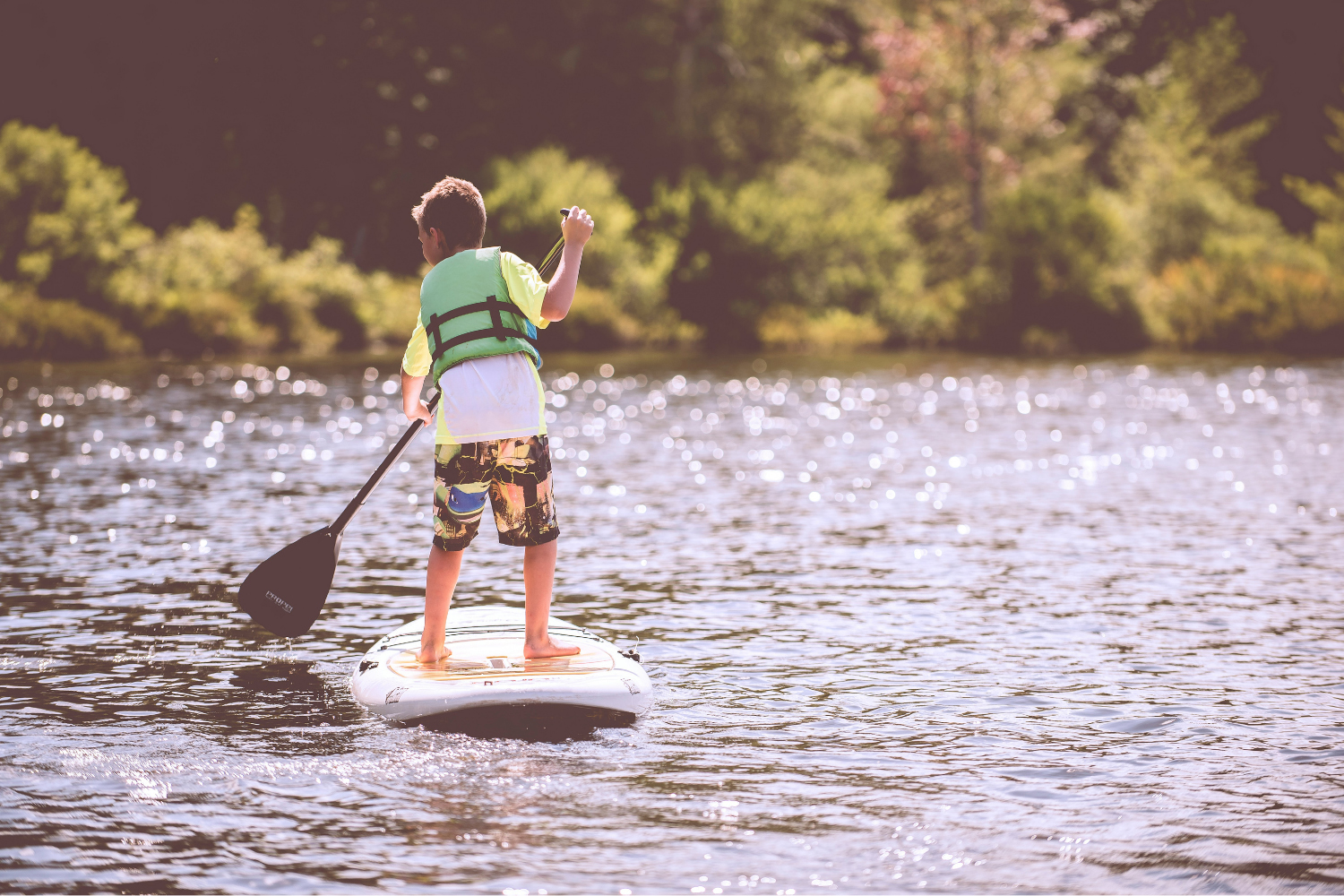 Raini in the Lake District: a child paddleboarding on a lake